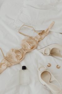 Kaboompics - Beige satin bra with lace and underwire - heeled shoes - perfume - gold earrings