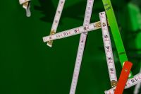 Kaboompics - Extandable wooden ruler on a green background