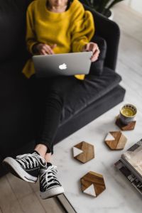 Kaboompics - Woman with legs on the coffee table, wearing converse sneakers and working on her laptop