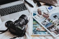 Kaboompics - Silver laptop, a camera, magazines, sunglasses and a brown cosmetics bag