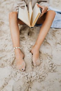 Kaboompics - A woman reads on the beach in the summer