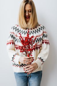 Kaboompics - Woman in a white Christmas sweater holds rowanberry branch