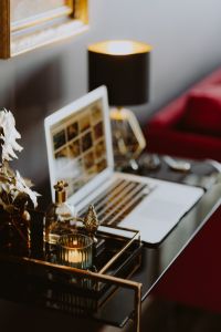 Kaboompics - Elegant home office with golden accessories. MacBook, candle, fragrances