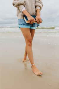 Kaboompics - A young woman with a book on the seashore