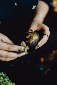 Woman Painting Black & Gold Easter Eggs