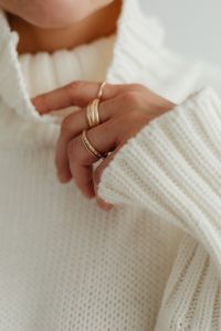Woman in white sweater - gold rings - jewelry