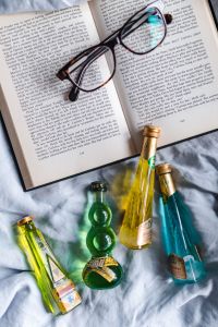 Kaboompics - Group of colorful little bottles with liqueurs & book with glasses