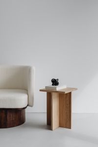 Modern oak side table - armchair with light boucle fabric - minimalist interior - book