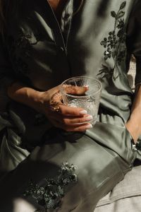 Kaboompics - Woman in Satin Ensemble with French Manicure Holding a Glass of Water