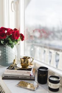 Gold cup of coffee and red roses bouqet