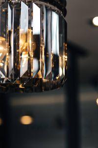 Kaboompics - Elegant black designer chandelier with a lit lightbulb