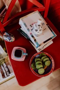 Kaboompics - Coffee, Green Tea Cookies, Books on the Red Chair