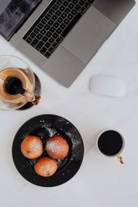 Kaboompics - Marble desk with laptop, homemade Polish doughnuts and coffee