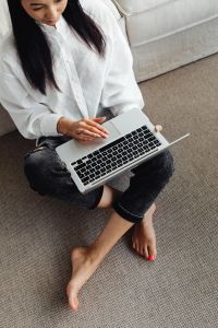 Kaboompics - Adult young Asian woman sits in living room and works on laptop