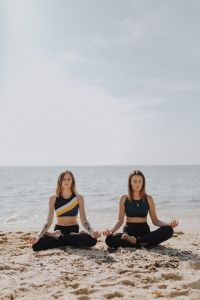 Kaboompics - Women doing yoga on the beach