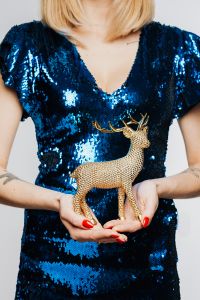 Kaboompics - Woman in Blue Dress Holds Gold Reindeer