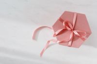 Light pink velvety box with satin ribbon on white marble