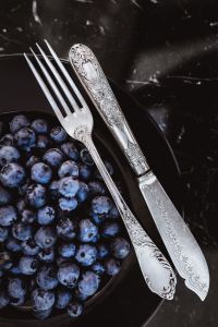 Kaboompics - Fresh blueberries on a black plate with vintage cutlery