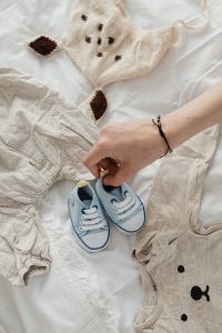 Pregnant Woman Folding Clothes For Her Baby