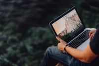 Kaboompics - A man using a Macbook laptop at the seaside