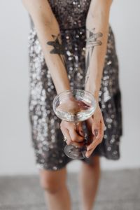 Kaboompics - Woman in a Sequin Dress is Holding a Glass of Champagne, White Background