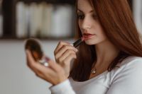 Kaboompics - Young beautiful woman doing her make up with lipstick
