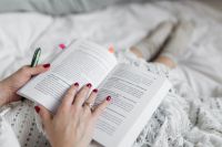 Soft photo of woman on the bed with the book