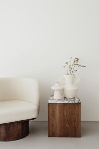 Wooden side table with marble top - bright ceramic vases - upholstered armchair