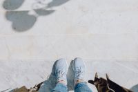 Kaboompics - A woman dressed in blue jeans and sneakers is standing on a white marble staircase