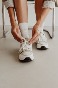 Kaboompics - Woman ties sneakers - long white socks