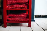 Kaboompics - Red woolen fabric stacked on a little red cupboard