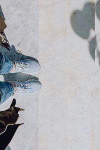 Kaboompics - A woman dressed in blue jeans and sneakers is standing on a white marble staircase