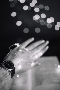 Kaboompics - Female hand, fairy lights, book