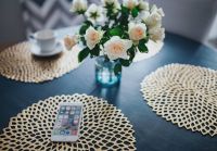 Round breakfast table with golden coffee mats and white flowers