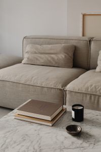 Living room - gray beige sofa - marble coffee table - coffee table books - candle