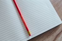 Kaboompics - Notebook with a red pencil on a wooden desk