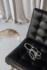 Kaboompics - Pearl necklaces - jewelry - black leather chair - Ludwig Mies van der Rohe - Lounge chair - Barcelona chair
