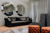 Kaboompics - Black leather sofa and big mirrors in living room.