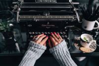 Kaboompics - Woman typing on an old typewriter