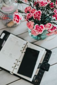 Organizer, mobile phone and lovely pink flowers