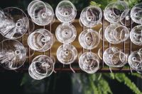 A big bunch of wine glasses hanging from a holder