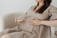Pregnant woman drinks water with lemon