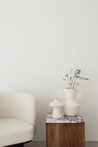 Wooden side table with marble top - bright ceramic vases - upholstered armchair