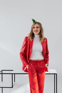 Kaboompics - Woman in a red jacket and a white shirt stands on a white background