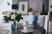 Round breakfast table with golden coffee mats and white flowers