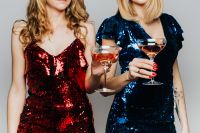 Two Women in Green and Red Dress Holding Glass of Wine