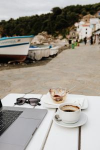 Kaboompics - Working with a laptop by the sea. Cup of coffee and delicious tiramisu, Marina di Puolo, Italy