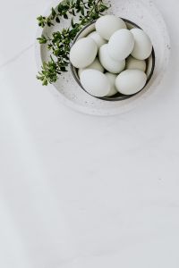 Easter flat lay with green eggs on a white marble