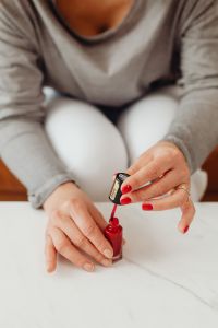Kaboompics - Closeup of a woman painting her nails with red nail polish