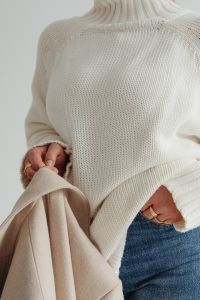 Kaboompics - Woman in white sweater - gold rings - jewelry - jeans - beige wool jacket